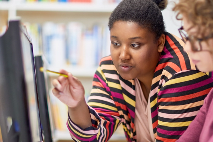 image of woman instructor working with student in front of a computer