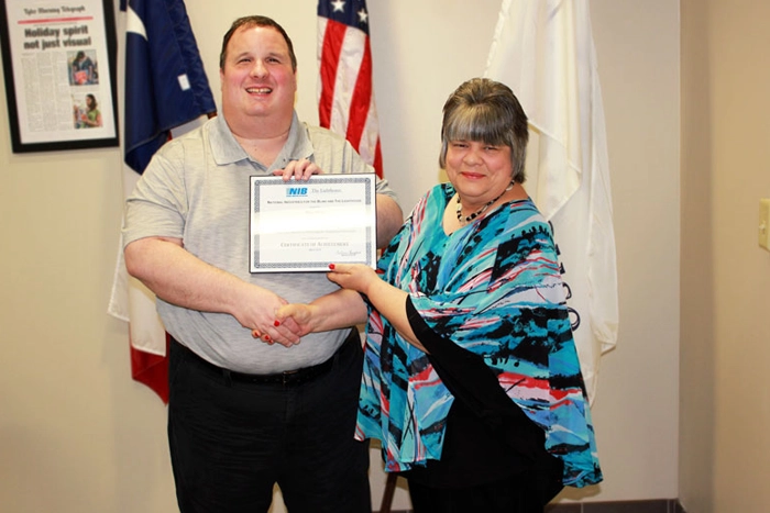 Low Vision instructor presenting certificate to blind student