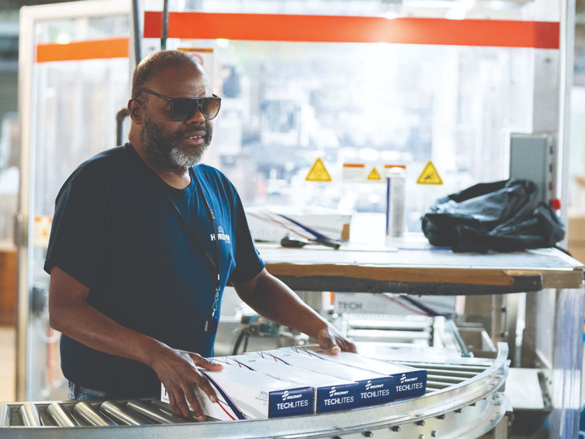 An employee working at a production line inside East Texas Lighthouse for the Blind.