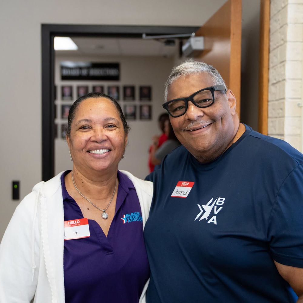 The Camp V team smiles from behind their resource table in the East Texas Lighthouse community room.